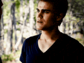 a close up of a man 's face in a dark room with trees in the background