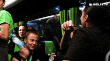 a group of people on a bus with wolfe tv written on the bottom right