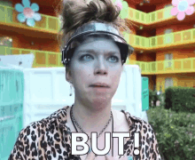 a woman wearing a leopard print shirt is holding a sign that says but