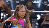 a woman in a pink and blue outfit is in a wrestling ring