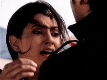 a man and a woman are hugging each other and the woman is crying