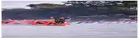 a group of people are rowing a boat in the water .
