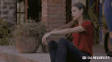 two women are sitting next to each other on a porch looking at a book .