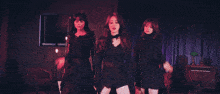 two women are standing next to each other in a dark room with red lights behind them