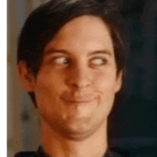 a close up of a man making a funny face with his eyes closed and smiling .
