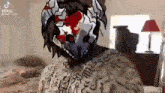 a man with a mask on his face is sitting on a bed .