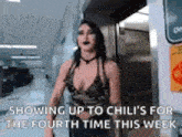 a woman in a plunging neckline is standing in a hallway .