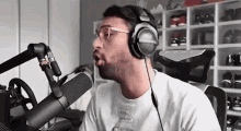a man wearing headphones is singing into a microphone .