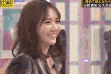 a woman is smiling in front of a sign that says ' aoi ' on it