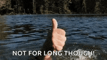 a person is giving a thumbs up in the water with the words `` not for long though '' .