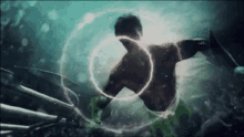 a man is swimming in the ocean with a light coming out of his back .