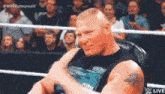 brock lesnar is sitting in a chair in a wrestling ring with his arm outstretched .