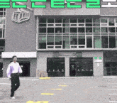a man is walking in front of a building that has the word ec on it