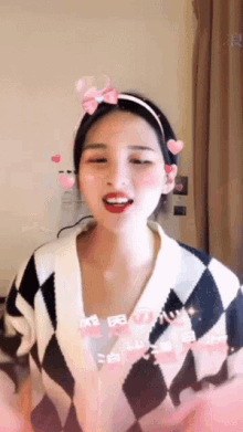 a girl wearing a headband with hearts and a bow on it