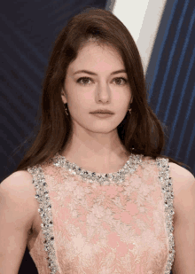 a close up of a woman wearing a pink dress with rhinestones