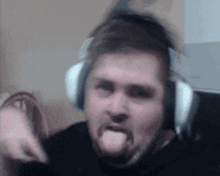 a man wearing headphones sticking his tongue out .