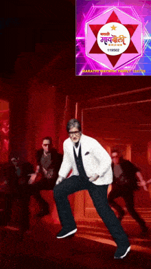 a man in a white suit is dancing in front of a sign that says marathi picture family