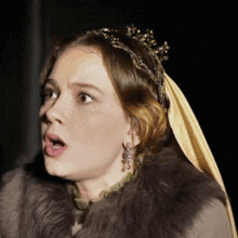 a woman wearing a fur coat and a tiara has her mouth open