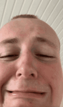 a close up of a man 's face with his eyes closed and his mouth open