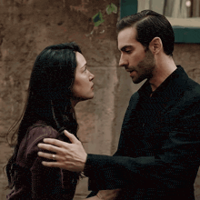 a man and a woman are looking at each other and the man has a wedding ring on his finger