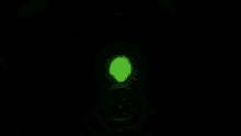 a green light is shining in the dark in a room .