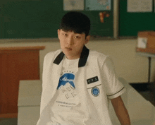 a boy wearing a white shirt with altered on the front