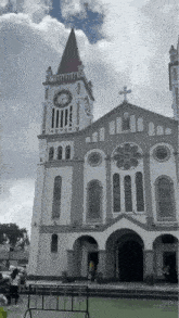 a church with a large clock tower and a cross on top