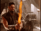 a man with a beard is holding a fire sword