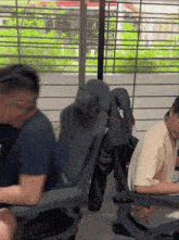 a man in a blue shirt sits in a chair with a bag that says ' pacific ' on it