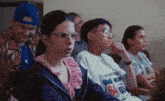a group of people sitting in a room with one wearing a shirt that says 64