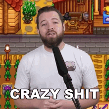 a man with a beard is standing in front of a microphone and saying crazy shit .