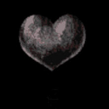 a broken heart with a red heart coming out of it on a black background .