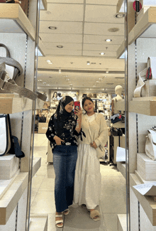 two women are taking a picture of themselves in front of a mirror