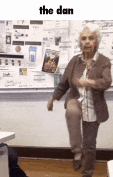 an older woman is standing on one leg in front of a white board with the word the dan above her