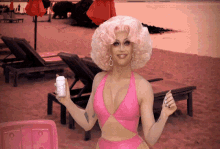 a woman in a pink bathing suit is holding a can of coca cola