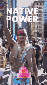 a man in a native american costume with a pink cake on his chest
