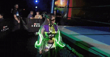 a woman in a purple and green outfit stands in front of a pro-wrestlers sign