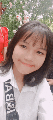 a young girl wearing a white shirt with a black strap that says ' a & b ' on it