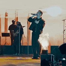 a man singing into a microphone on stage