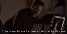 a man is looking at a framed picture and says i 'd like to bend her over the barrel