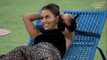 a woman is smiling while laying on a chair that says apowerrec big brother brasil