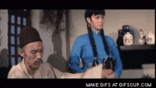 a man with a mustache is talking to a woman in a blue shirt