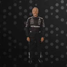 a man in a petronas racing suit is dancing