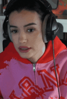 a woman wearing headphones is wearing a pink sweatshirt with the word rin on it