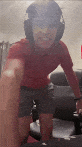 a man wearing headphones and a red shirt is kneeling down