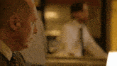 a man in a suit and tie looks at himself in a mirror