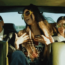 a woman wearing sunglasses is sitting in the back seat of a car with another woman