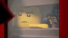 a lego head with a sad look on his face is behind a red curtain