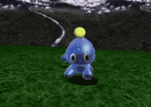 a green cartoon character is standing in the grass with a yellow ball in the background .