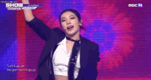a woman in a suit and tie is standing on a stage .